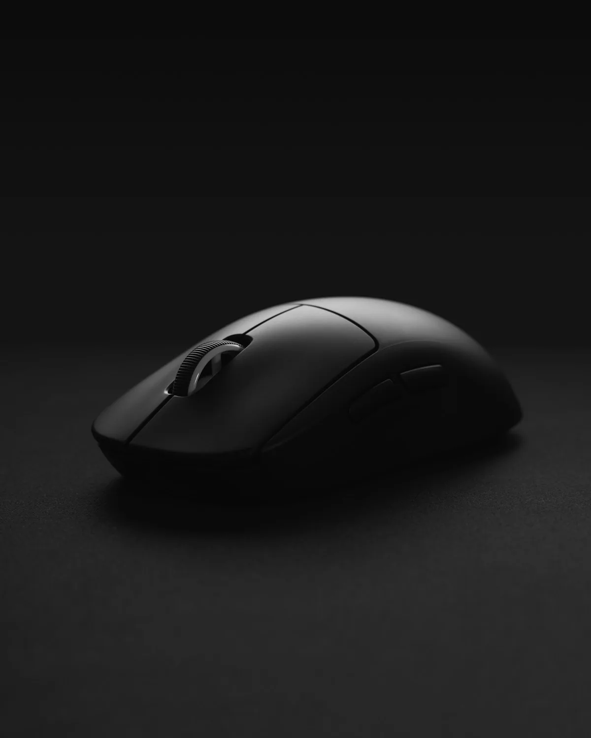 Contour wireless mouse in black on a dark surface