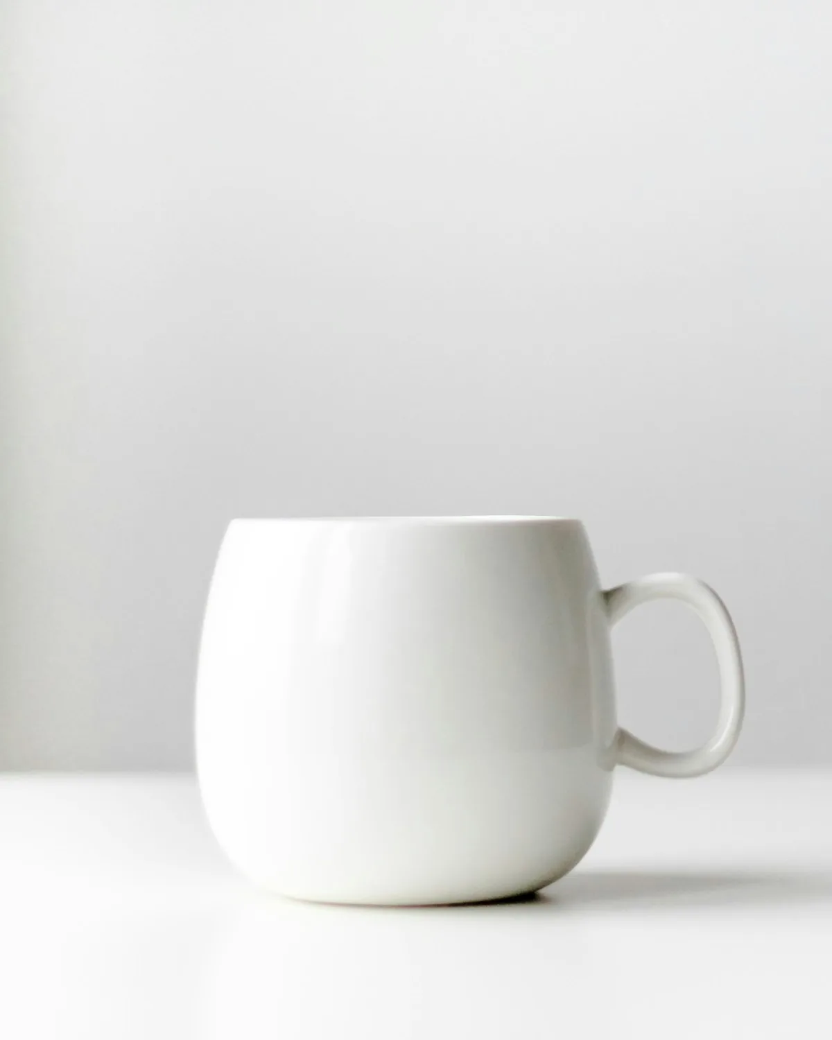 Everyday stoneware mug in oat on a pale surface