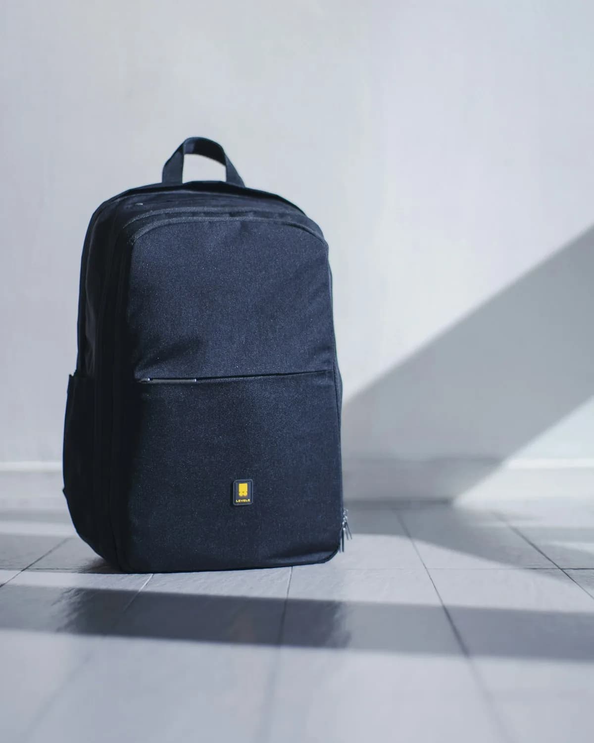 A navy Transit Daypack on a concrete floor